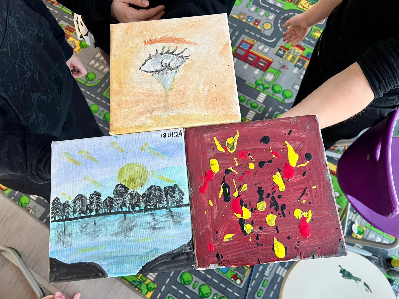 Die Kinder präsentieren stolz ihre Gemälde